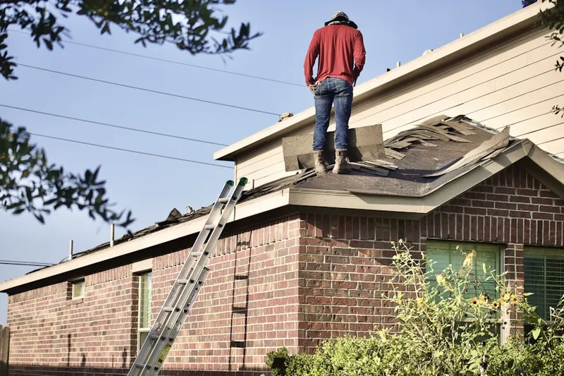 Professional roofer working on a residential roof in West Bay Drive